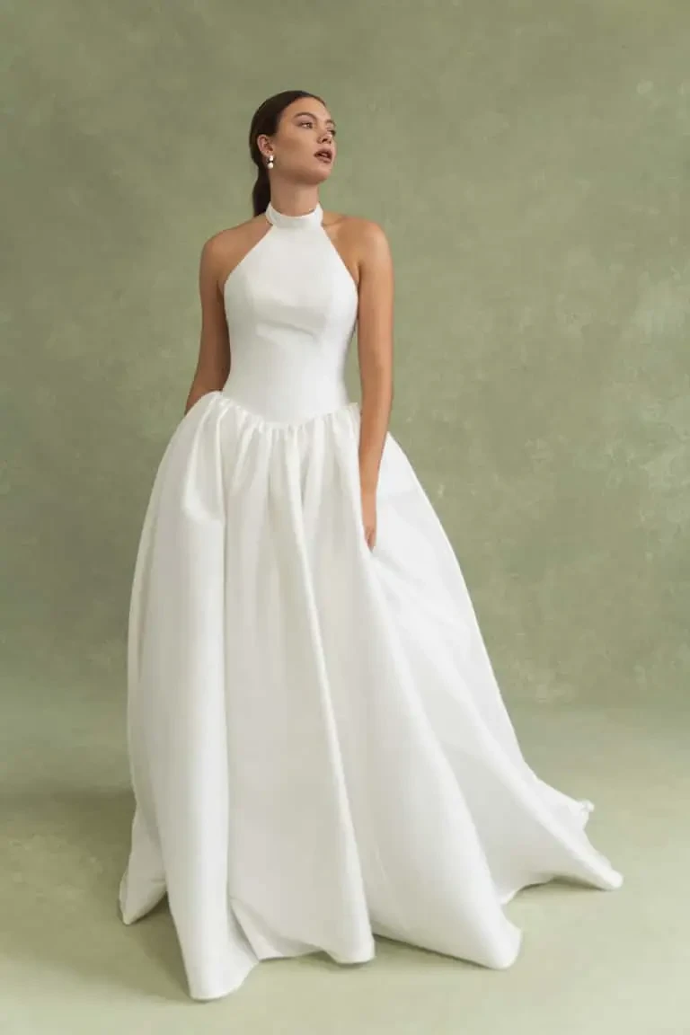 model is wearing a high neckline a-line wedding dress with a basque waist by jenny yoo