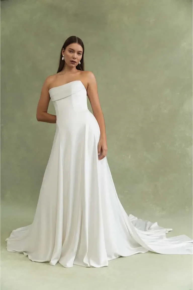 model is wearing a strapless a-line bridal gown by jenny yoo